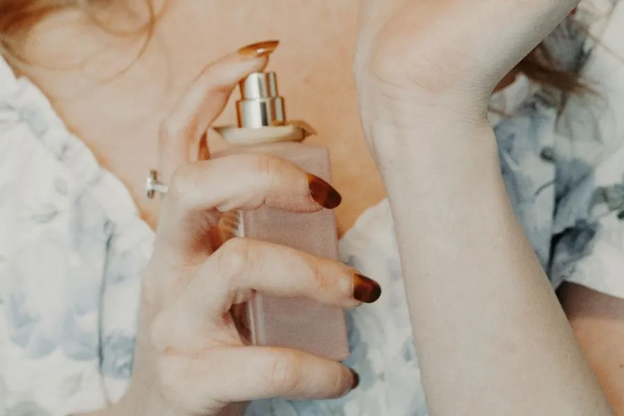 woman holding a bottle of perfume